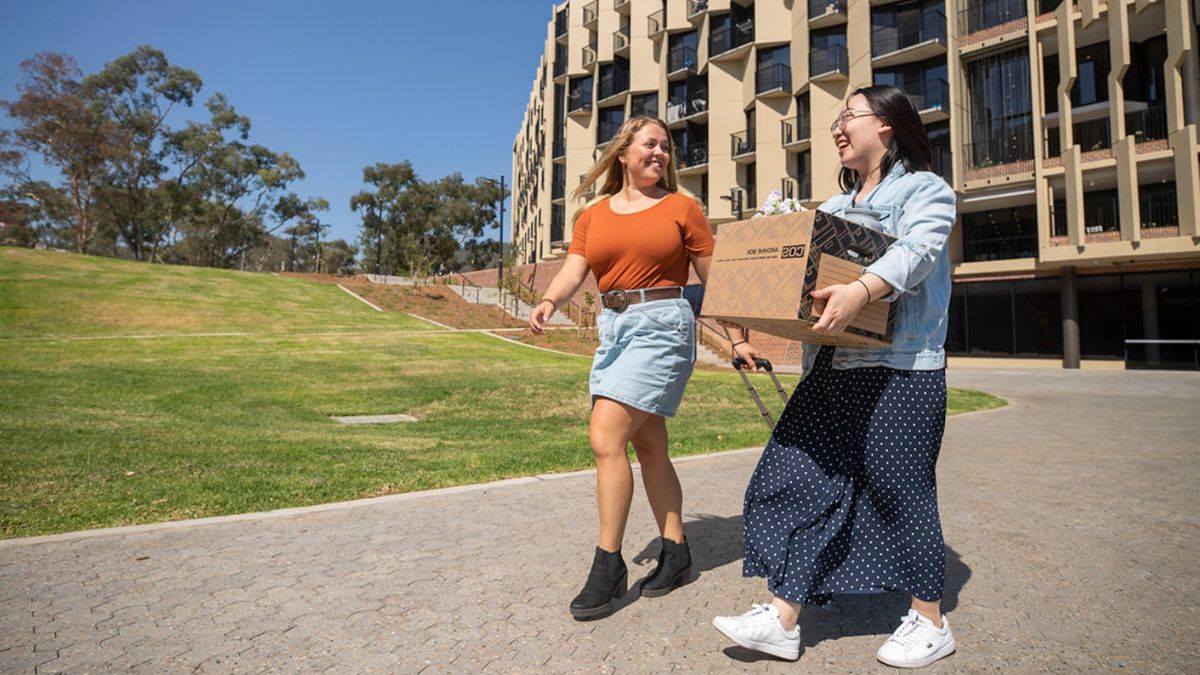 An ANU student helps a new arrival move into student accommodation.