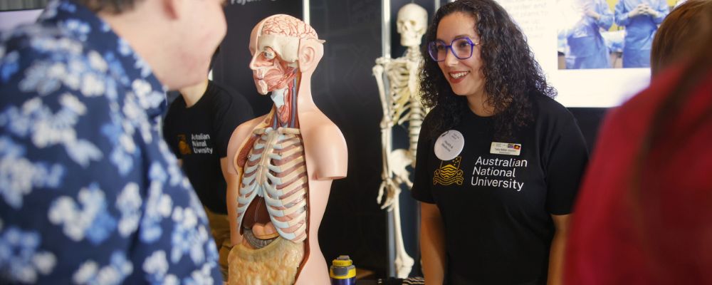 An ANU academic college representative talking to an attendee of an ANU event.