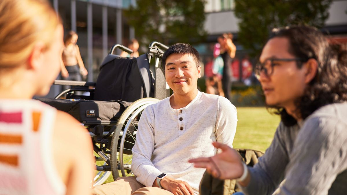 ANU students sit together on Kambri Lawns within the ANU campus in Canberra. 