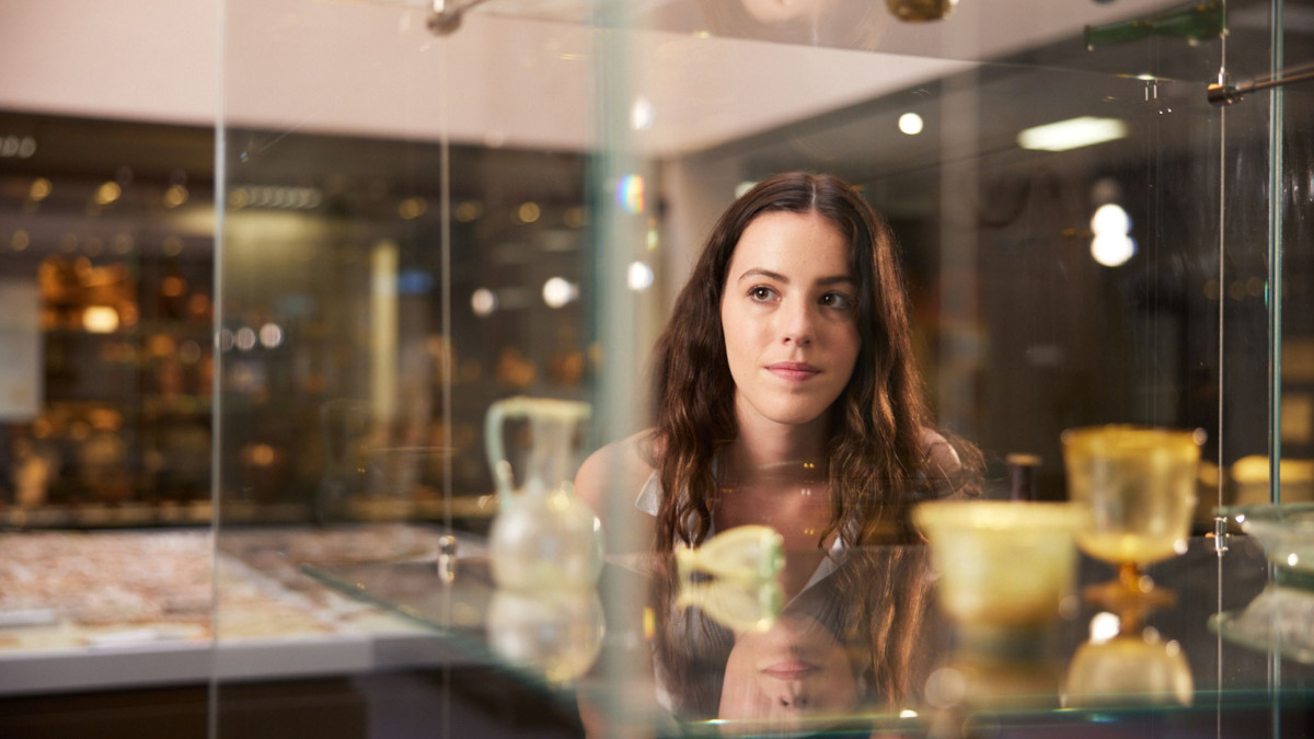 Female ANU student looks at glass case within archaeology collection at ANU in Canberra.