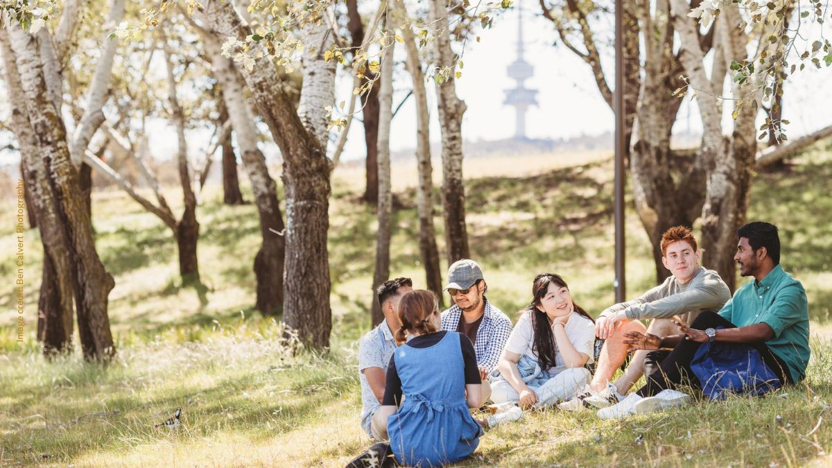 Students meeting at West Basin in the shade with views of Black Mountain Tower. 