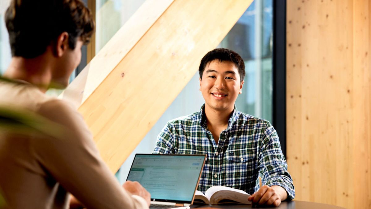 Two male students at the Australian National University study together in the Marie Reay Teaching Centre
