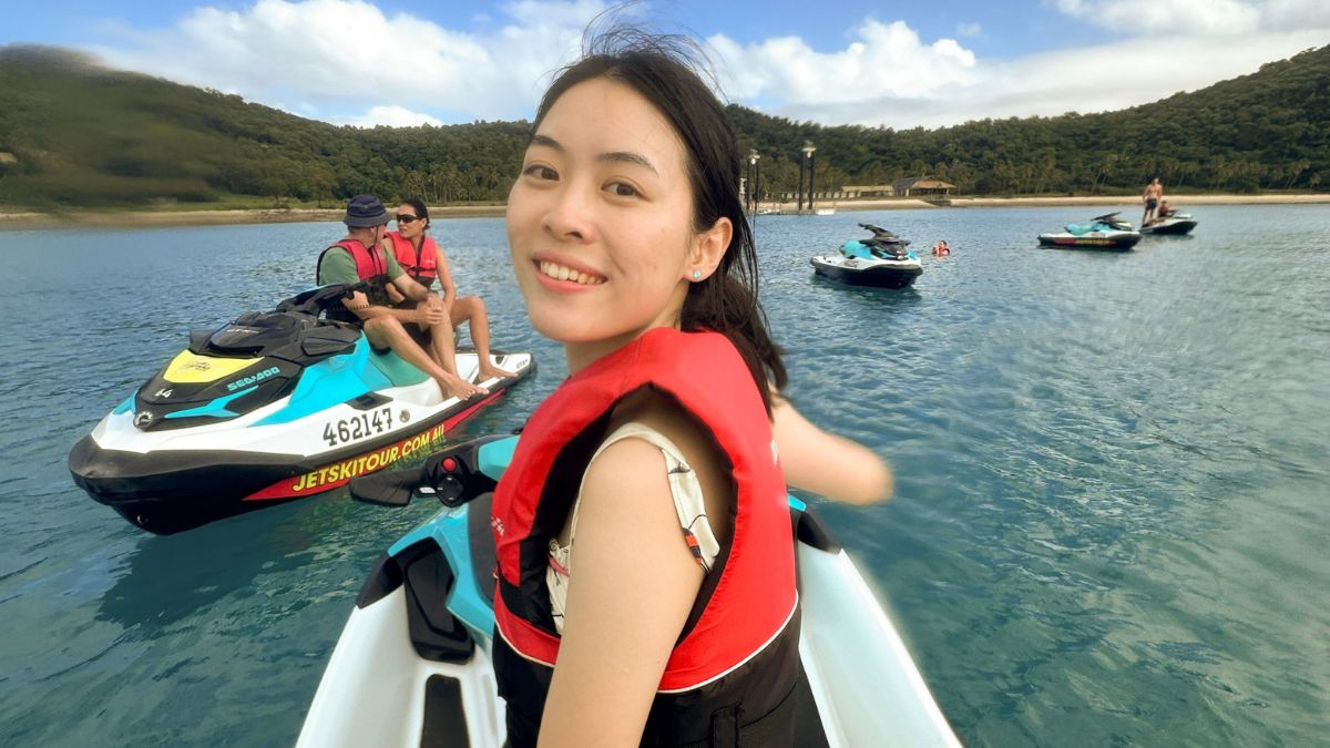 Eunice smiles back at the camera as she sits on a small boat wearing a life vest in Australia.
