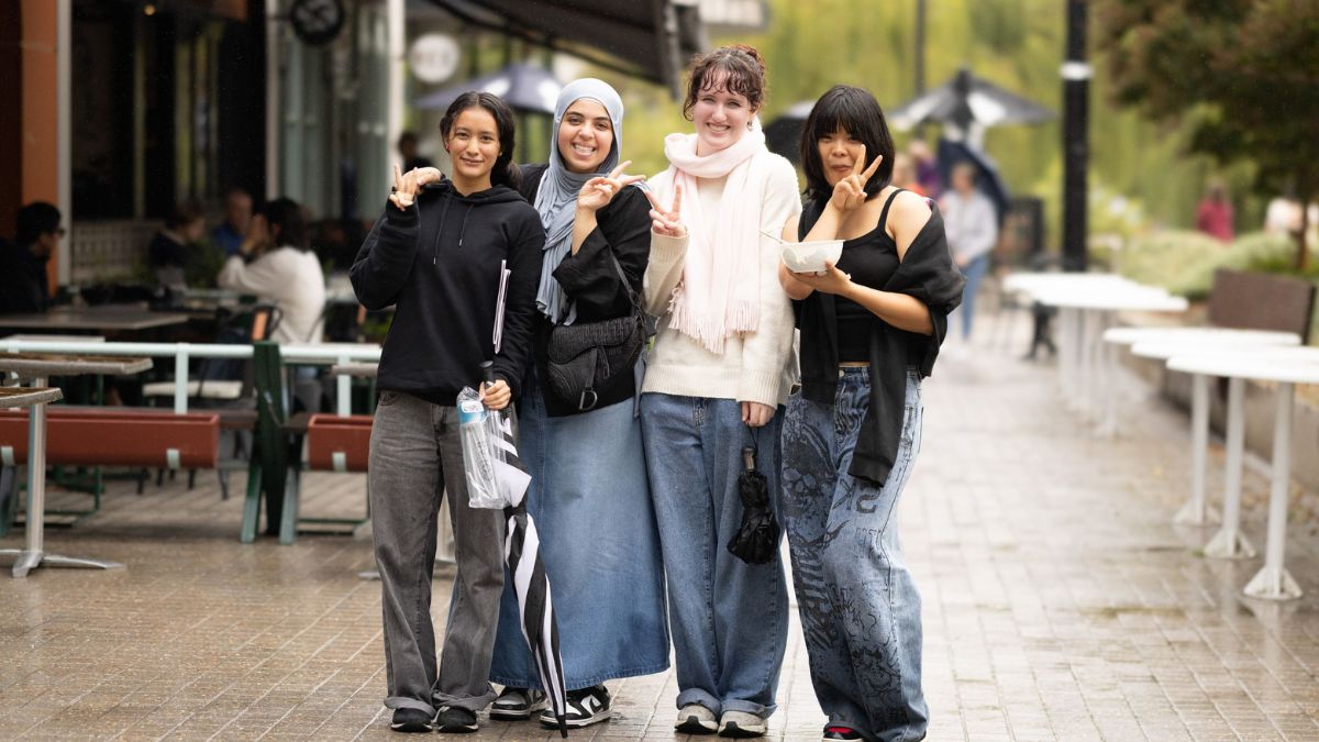 Four ANU students stand in the Kambri precinct at the 2025 ANU Open Day.