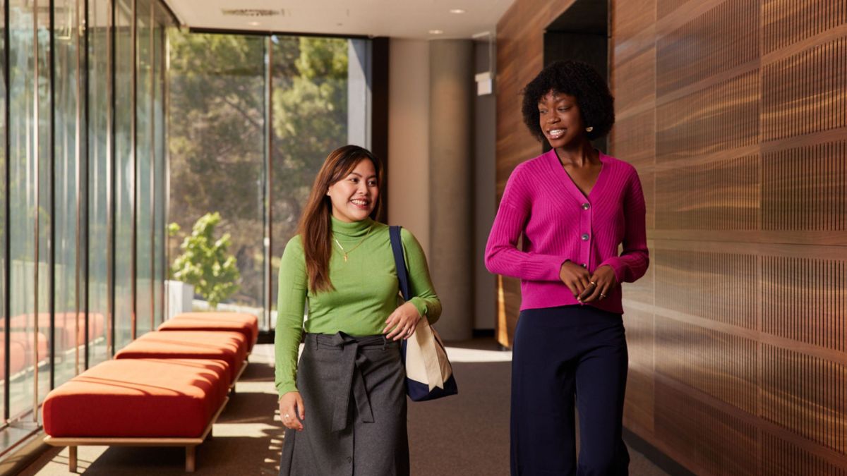 Two female ANU students walk down a corridor at the ANU Research School of Physics
