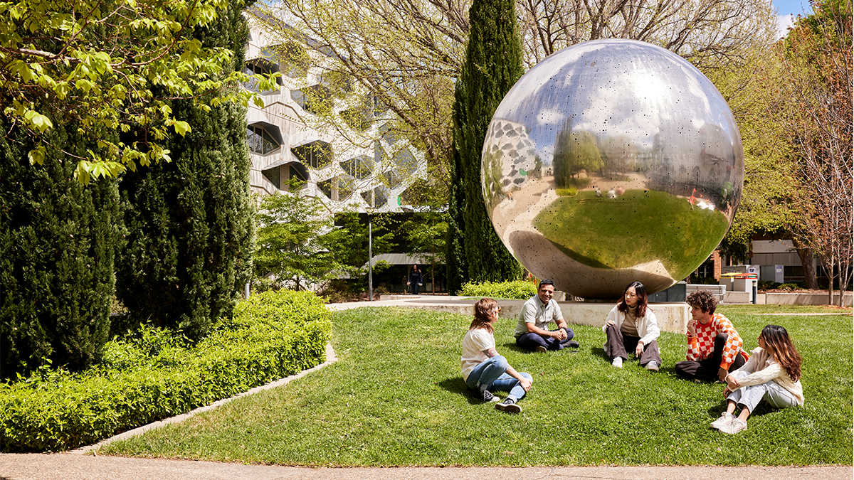 Five students sit in front of the UNA