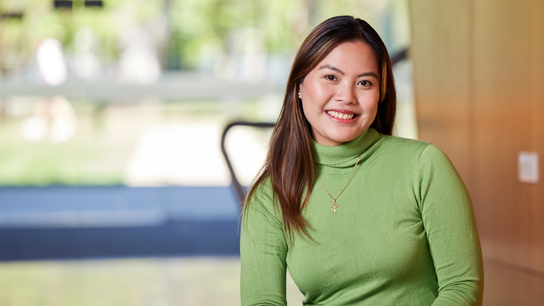 Person sitting down smiling towards camera